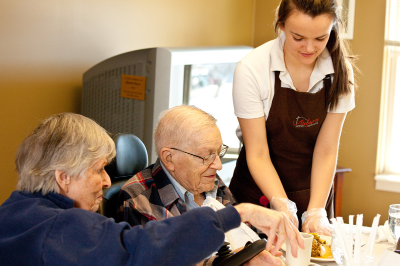 employee serving a meal to residents