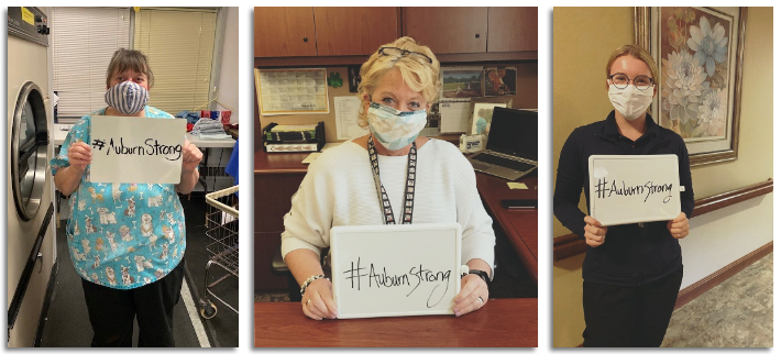Auburn Homes & Services employees holding #AuburnStrong signs.