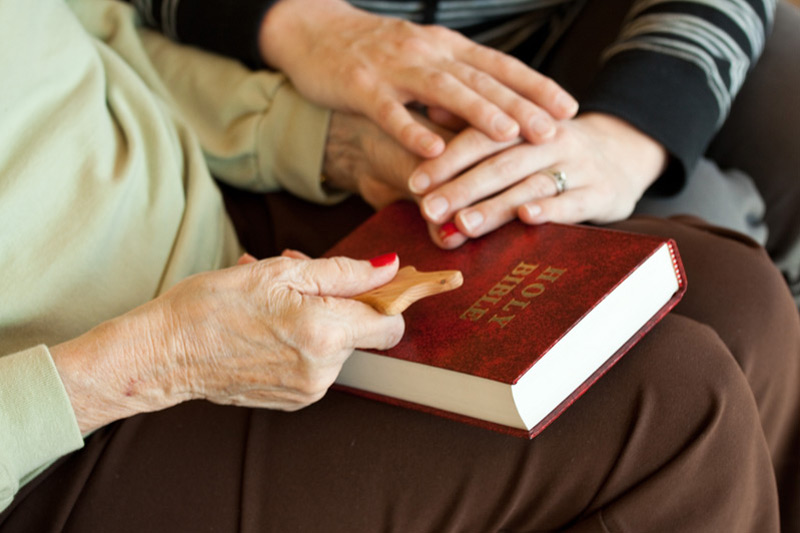 Auburn Homes resident and chaplain with Bible