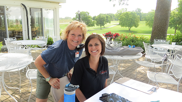 two women working at Auburn Golf Tournament