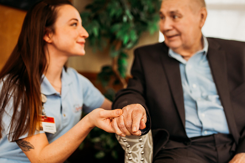At Auburn Courts in Chaska, a care attendant touches a resident’s hand