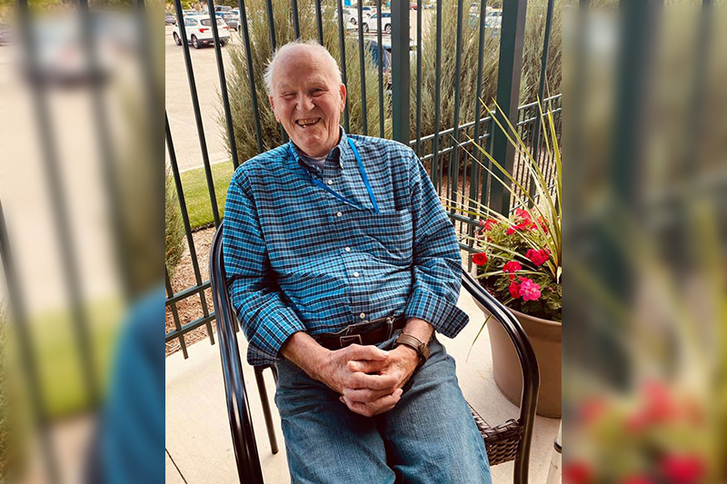 Man in chair outside Reflectiosn at Meadows memory care