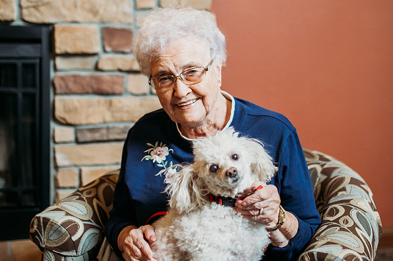 A resident of Auburn Meadows Assisted Living in Waconia sits with her dog